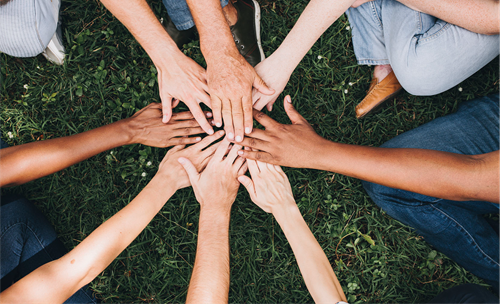 Hands at the center in a group huddle.