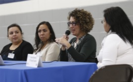 Four adults participating in a panel discussion Four adults participating in a panel discussion